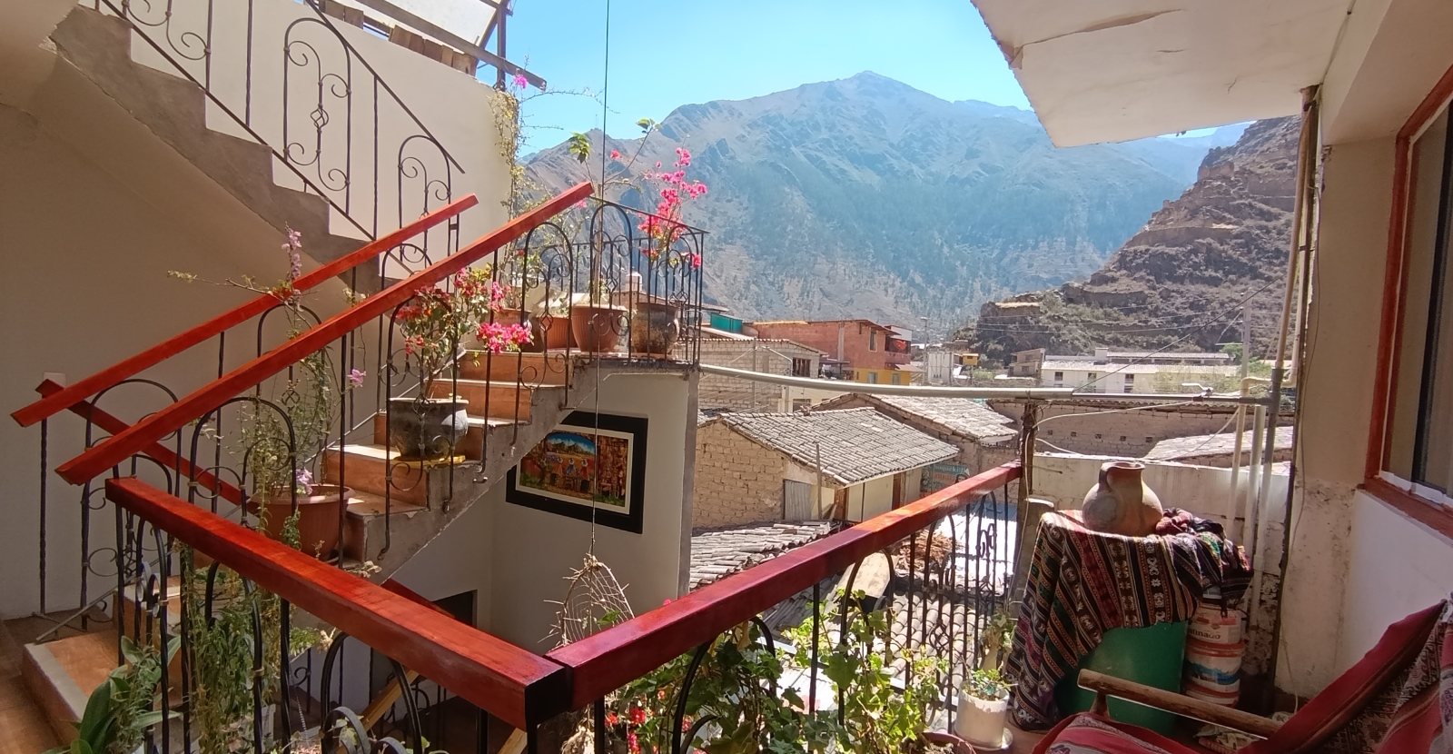 Escaleras y terraza del hotel con flores y vista al valle
